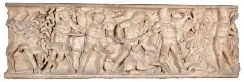 A beige sarcophagus covered in relief carvings of men and animals.