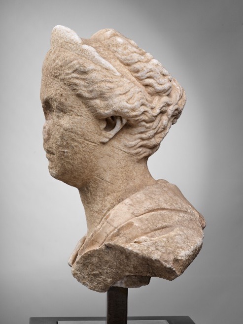 A stone bust of Sabina facing left. Her hair is gathered up, and the nose is missing.